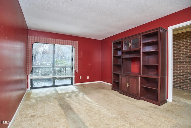 unfurnished living room featuring light carpet and a textured ceiling