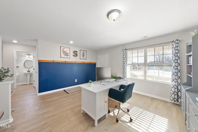 home office featuring light hardwood / wood-style floors and sink