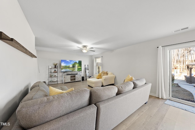 living room with ceiling fan and light hardwood / wood-style flooring