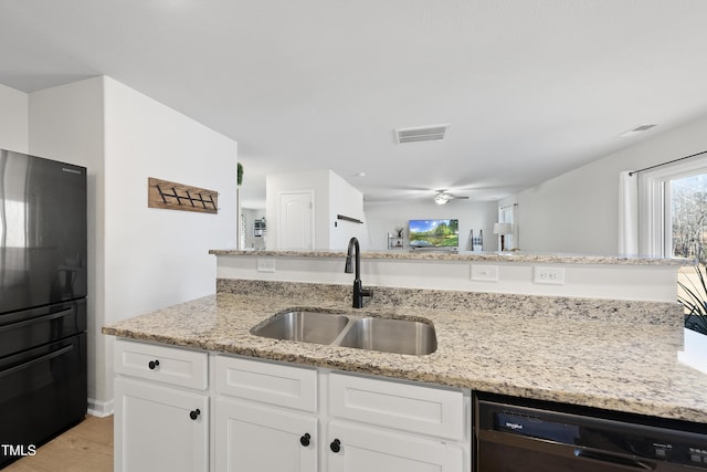 kitchen featuring white cabinetry, ceiling fan, light stone countertops, black appliances, and sink