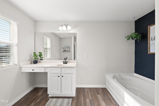 bathroom with hardwood / wood-style flooring, a bathtub, and vanity