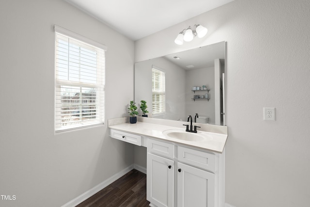 bathroom featuring toilet, vanity, and hardwood / wood-style floors