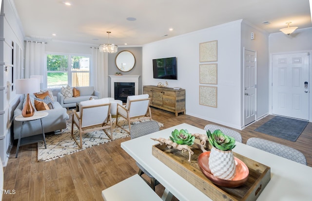 living room with a chandelier, light hardwood / wood-style floors, and ornamental molding