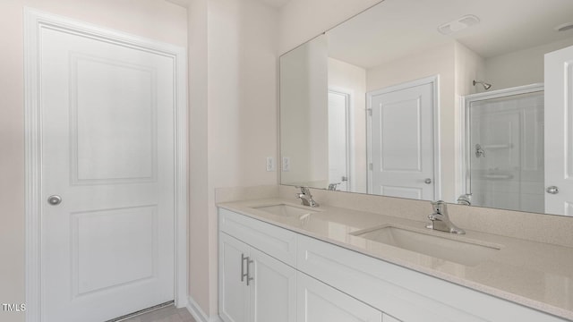 full bathroom with double vanity, a stall shower, and a sink