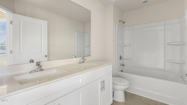 bathroom featuring a sink, bathing tub / shower combination, toilet, and double vanity