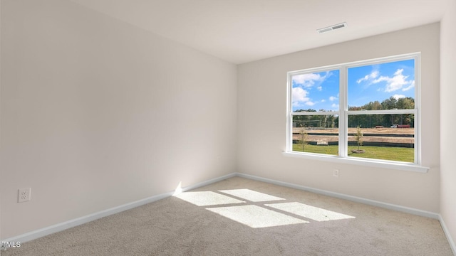 carpeted empty room featuring visible vents and baseboards