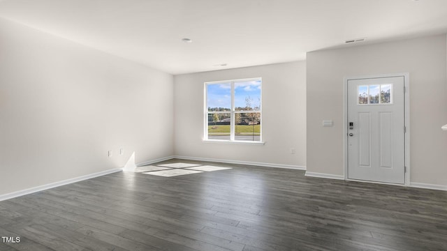 foyer entrance featuring dark wood-style floors, visible vents, and baseboards