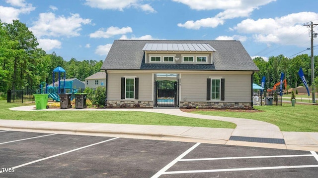 exterior space with uncovered parking, a front yard, playground community, and fence