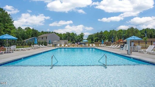 pool with a patio and fence