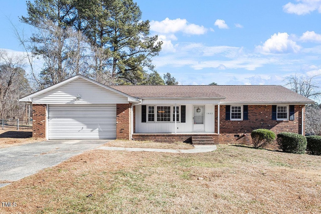 ranch-style house featuring a front lawn, a porch, and a garage