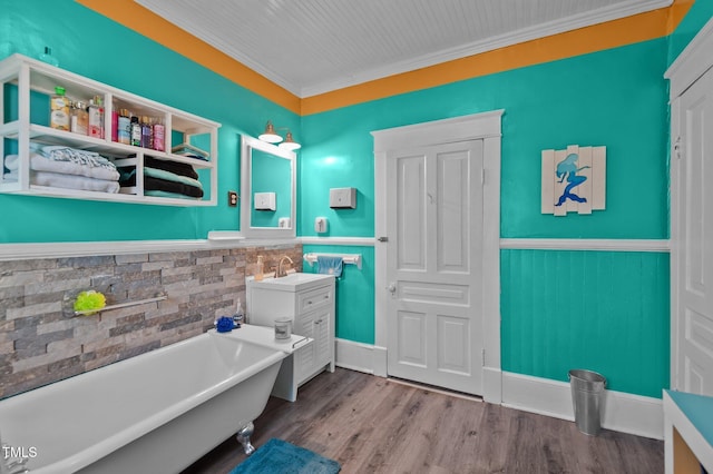 bathroom with vanity, hardwood / wood-style flooring, crown molding, and a bathing tub