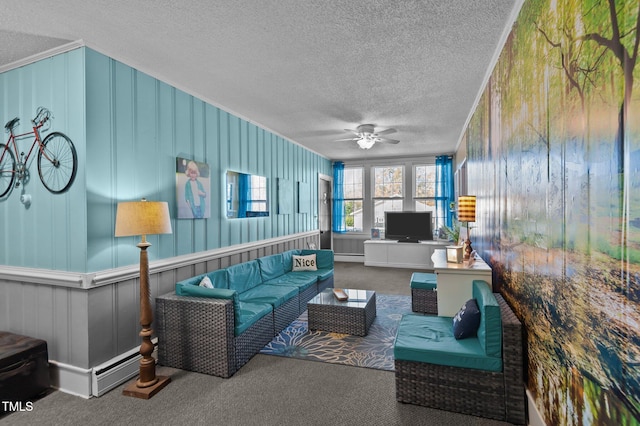 carpeted living room featuring ceiling fan, crown molding, and a baseboard heating unit