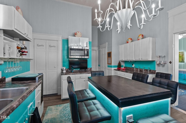 kitchen featuring white cabinets, dark wood-type flooring, and a notable chandelier