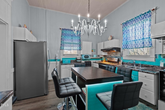 kitchen featuring an inviting chandelier, white cabinets, sink, appliances with stainless steel finishes, and a kitchen island