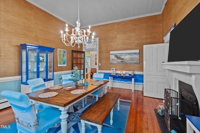 dining area featuring crown molding, a chandelier, and dark hardwood / wood-style floors