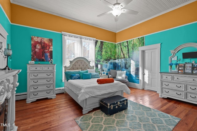 bedroom with hardwood / wood-style floors, baseboard heating, ceiling fan, and ornamental molding