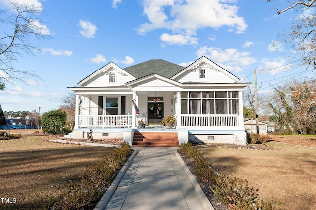 view of front facade with a sunroom, covered porch, and a front yard