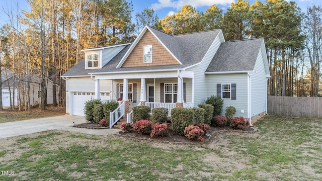 view of front facade featuring a porch, a garage, and a front yard