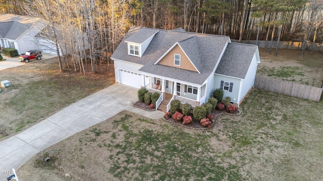 view of front facade featuring covered porch, a garage, and a front lawn