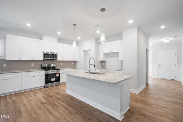 625 Spellbrook Rd, Zebulon, NC 27597 - kitchen with light wood-type flooring, decorative backsplash, white cabinets, stainless steel appliances, and a sink