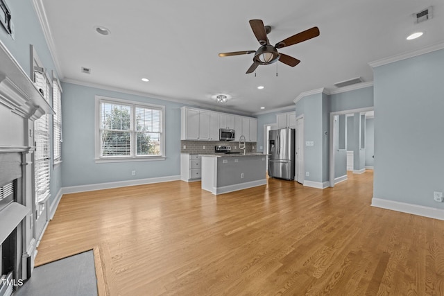 unfurnished living room with ceiling fan, crown molding, sink, and light hardwood / wood-style flooring