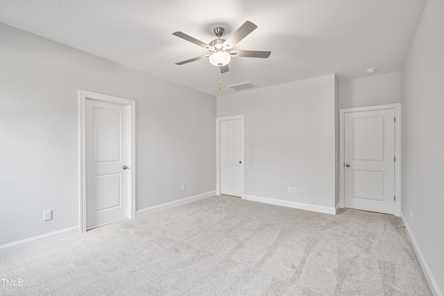 empty room featuring baseboards, visible vents, a ceiling fan, and light colored carpet