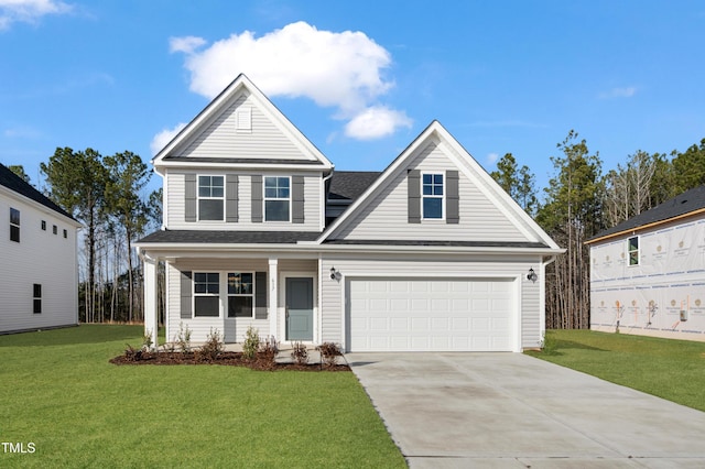 view of property featuring a garage, a front yard, and covered porch