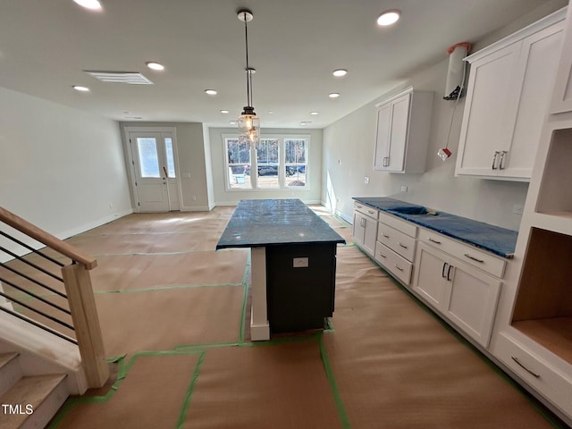 kitchen with white cabinetry, decorative light fixtures, and a kitchen island