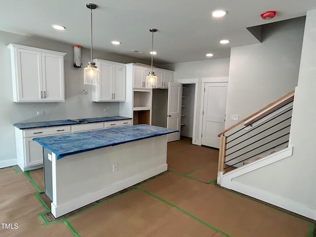 kitchen with a kitchen island, pendant lighting, and white cabinets