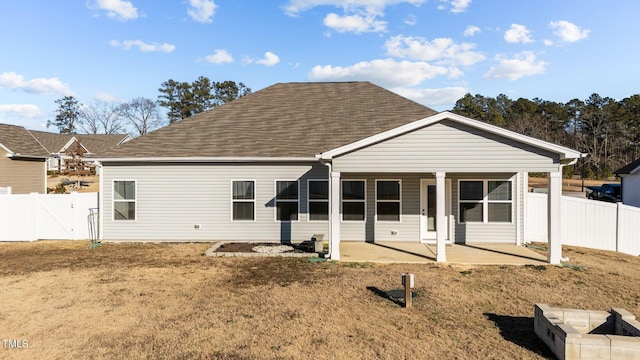 back of house featuring a lawn, a patio, a fenced backyard, roof with shingles, and a gate