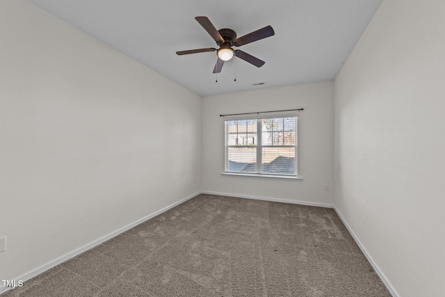 carpeted spare room featuring a ceiling fan and baseboards