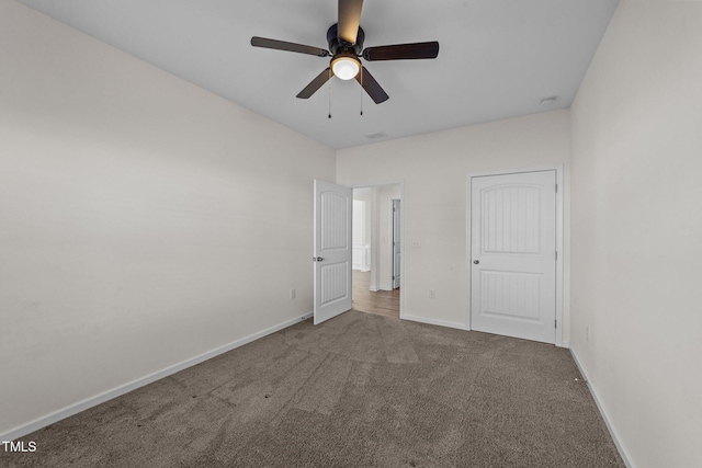 unfurnished bedroom with carpet floors, a ceiling fan, and baseboards