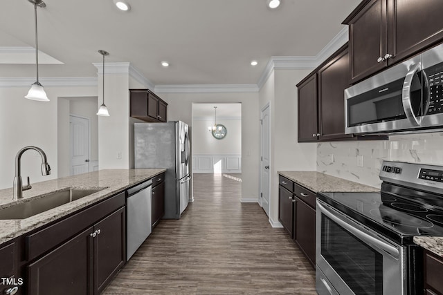 kitchen with decorative backsplash, appliances with stainless steel finishes, ornamental molding, dark brown cabinets, and a sink