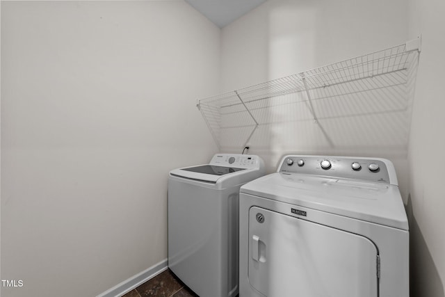 washroom featuring laundry area, washing machine and dryer, and baseboards