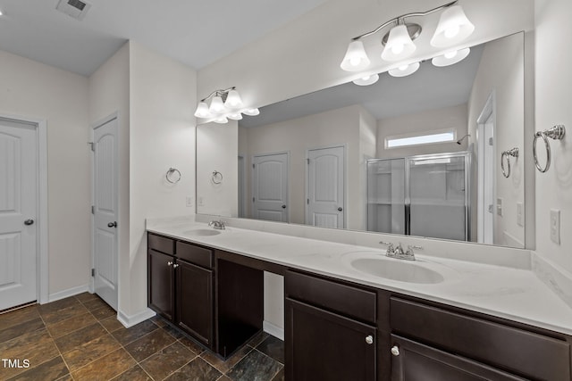 bathroom featuring visible vents, a sink, a shower stall, and double vanity