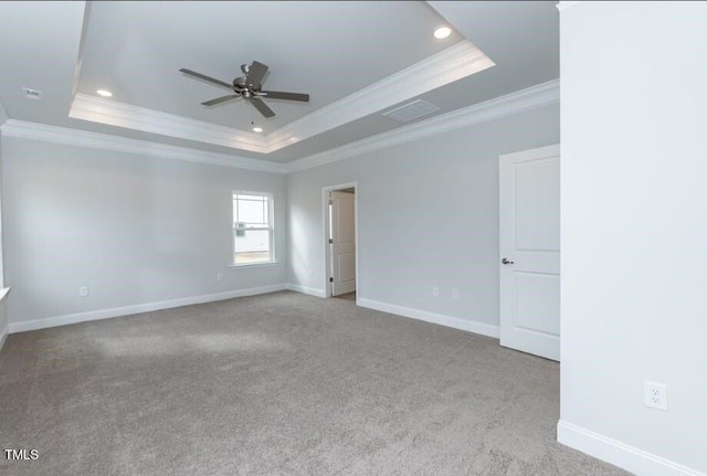 carpeted empty room featuring ornamental molding, ceiling fan, and a tray ceiling