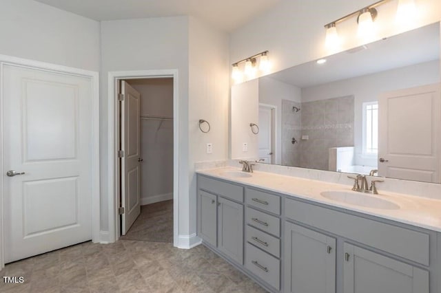 bathroom with tiled shower and vanity