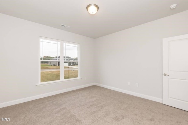 spare room featuring light colored carpet