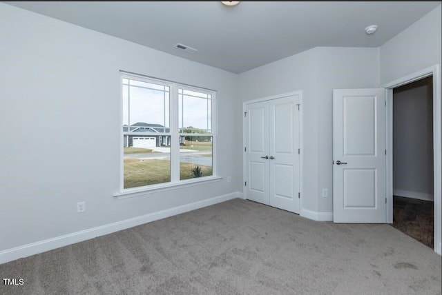 unfurnished bedroom featuring light carpet and a closet