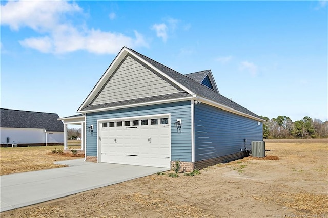 view of side of home featuring cooling unit and concrete driveway