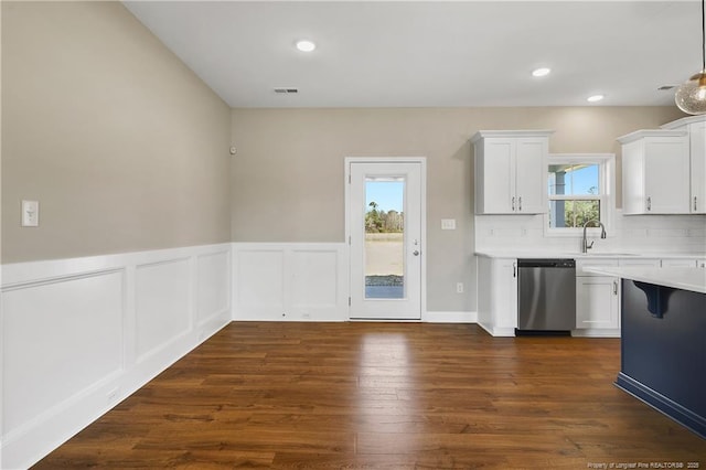 kitchen with visible vents, stainless steel dishwasher, light countertops, decorative backsplash, and dark wood-style flooring