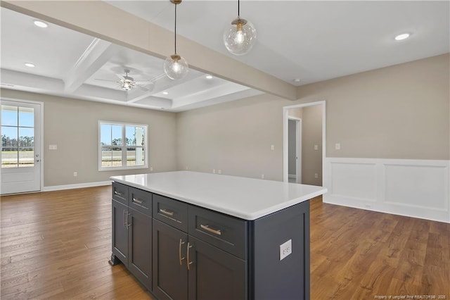 kitchen with dark wood-style floors, beam ceiling, light countertops, decorative light fixtures, and open floor plan