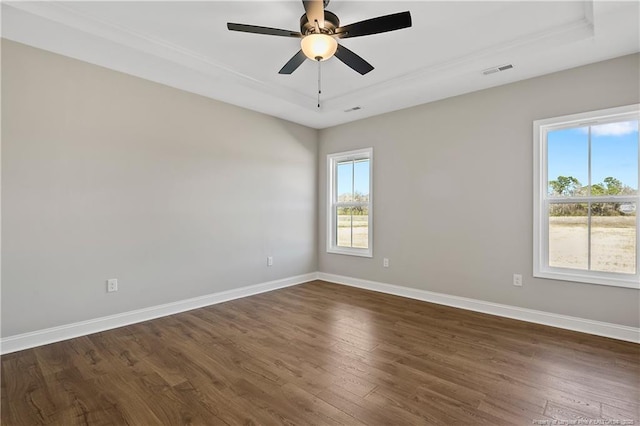 unfurnished room with dark wood-style floors, baseboards, visible vents, and ceiling fan