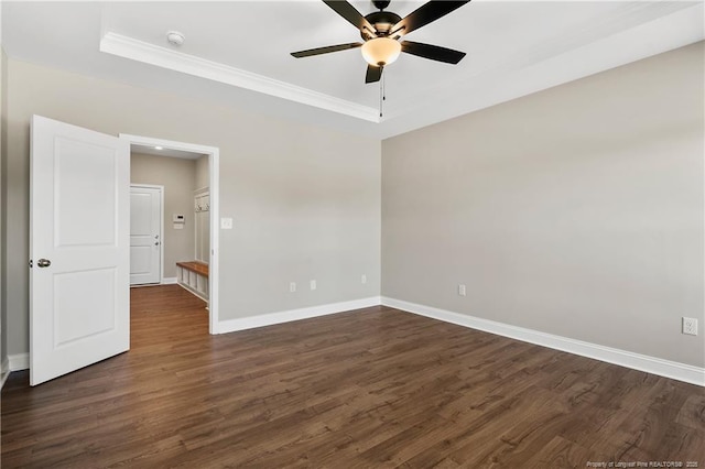 unfurnished room with a ceiling fan, a tray ceiling, baseboards, and dark wood-style flooring