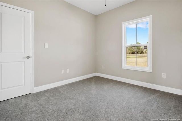 carpeted empty room featuring baseboards