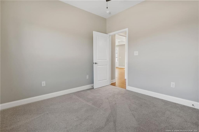 unfurnished room with baseboards and carpet flooring