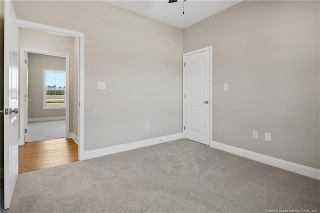 unfurnished room featuring baseboards, carpet, and a ceiling fan