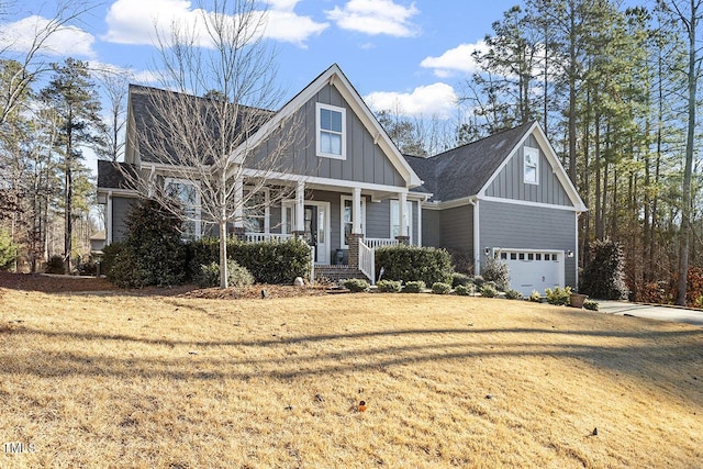 craftsman inspired home featuring covered porch, a front yard, and a garage