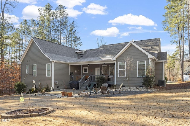 view of front of home with cooling unit, an outdoor fire pit, and a front lawn