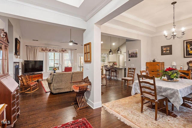 dining area featuring ceiling fan with notable chandelier, dark hardwood / wood-style flooring, and crown molding